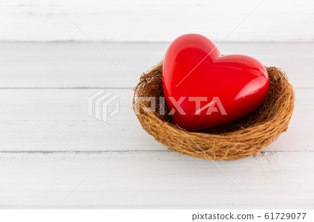 Red Heart Inside bird nest on white wood Red Heart Inside bird nest on white wood 61729077