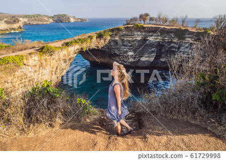 Young woman tourist near Broken Beach in Nusa Penida, Indonesia Angel's BillaBong Beach. Popular 61729998