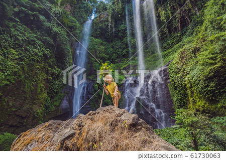 Cute boy depicts the king of the jungle against the backdrop of a waterfall. Childhood without 61730063