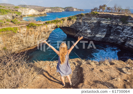 Young woman tourist near Broken Beach in Nusa Penida, Indonesia Angel's BillaBong Beach. Popular 61730064