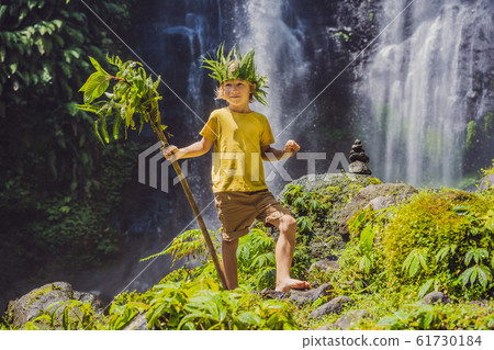 Cute boy depicts the king of the jungle against the backdrop of a waterfall. Childhood without 61730184