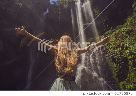 Woman in turquoise dress at the Sekumpul waterfalls in jungles on Bali island, Indonesia. Bali Woman in turquoise dress at the Sekumpul waterfalls in jungles on Bali island, Indonesia. Bali 61730873