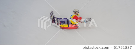 man snow tubing from hill. winter activity concept BANNER, LONG FORMAT 61731887