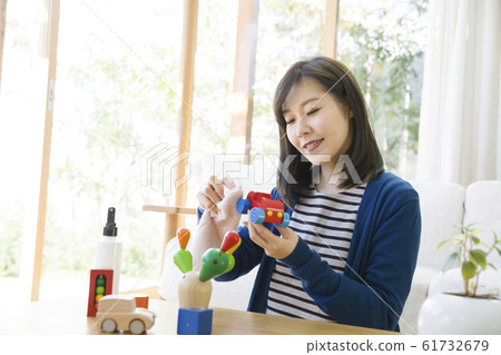 Mother removing bacteria from children's toys 61732679