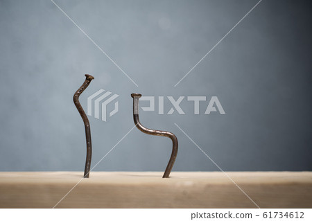 Two bent nails driven into a board. Concept stoop, 61734612