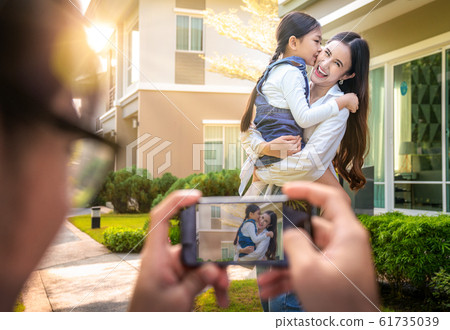 Father mother and daughter take a photo togather Father mother and daughter take a photo togather 61735039