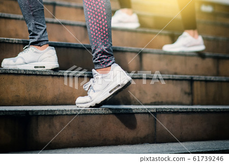 Close up on shoe athlete, Woman running in city. Close up on shoe athlete, Woman running in city. 61739246
