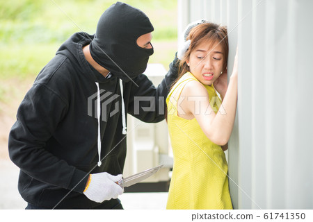 Bandit wear black mask with a knife attacks a girl Bandit wear black mask with a knife attacks a girl 61741350