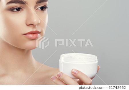 Woman Holding Cosmetic Cream. Beauty Face. 61742662