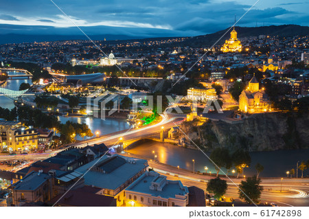 Tbilisi, Georgia. Evening Night View Of Georgian Capital Skyline. Scenic Top View Of Summer Evening Cityscape Of Tbilisi, Georgia In Illumination Lights With All Famous Landmarks, Sightseeings Tbilisi, Georgia. Evening Night View Of Georgian Capital Skyline. Scenic Top View Of Summer Evening Cityscape Of Tbilisi, Georgia In Illumination Lights With All Famous Landmarks, Sightseeings 61742898