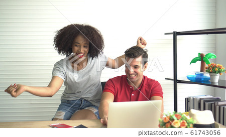 Happy Multi ethnic couple looking for Summer deal on internet 61743056