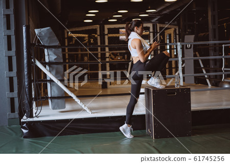 Beautiful young woman in sportswear posing on camera in the gym Beautiful young woman in sportswear posing on camera in the gym 61745256