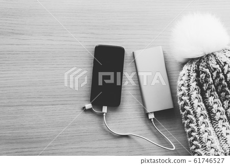 Smartphone in winter charging from power bank 61746527