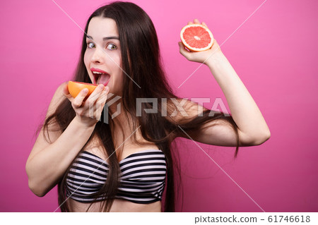 happy girl holding halves of grapefruit near face happy girl holding halves of grapefruit near face 61746618