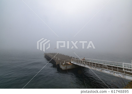 A pier surrounded by the fog of Lake Chuzenji A pier surrounded by the fog of Lake Chuzenji 61748895