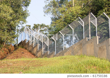 Tall security fence define boundary prevent 61750186