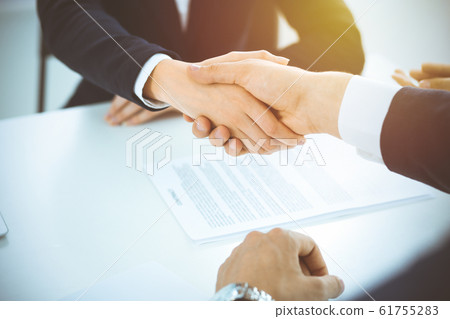 Business people shaking hands finishing up meeting or negotiation in sunny office. Business handshake and partnership concepts Business people shaking hands finishing up meeting or negotiation in sunny office. Business handshake and partnership concepts 61755283