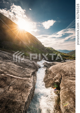 Kinsarvik, Hordaland, Norway. Water Stream Through Rocks In Hardangervidda Mountain Plateau. Sun Sunshine Above Rocky Landscape In Summer Sunny Day. Famous Norwegian Landmark And Popular Destination Kinsarvik, Hordaland, Norway. Water Stream Through Rocks In Hardangervidda Mountain Plateau. Sun Sunshine Above Rocky Landscape In Summer Sunny Day. Famous Norwegian Landmark And Popular Destination 61760328