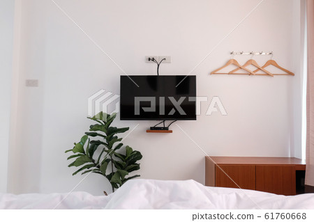 Interior view from bed, bedroom with television. 61760668