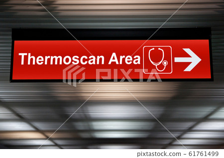 Thermoscan Area red sign with arrow direction hang from ceiling at the airport for outbreak control situation at passengers arriving terminal by Public Health Officials Thermoscan Area red sign with arrow direction hang from ceiling at the airport for outbreak control situation at passengers arriving terminal by Public Health Officials 61761499