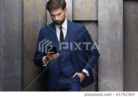 indoor photo of young handsome stylish businessman wearing suit indoor photo of young handsome stylish businessman wearing suit 61762364