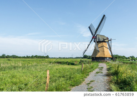 Wedelfelder Windmill. Old East Frisian mill on a meadow in rural landscape in Lower Saxony, Germany 61763859