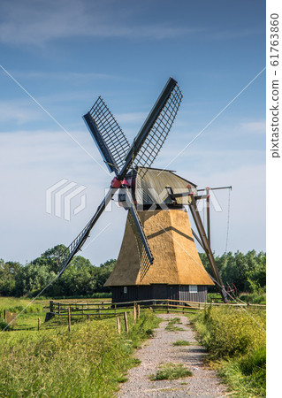 Wedelfelder Windmill. Old East Frisian mill on a meadow in rural landscape in Lower Saxony, Germany 61763860