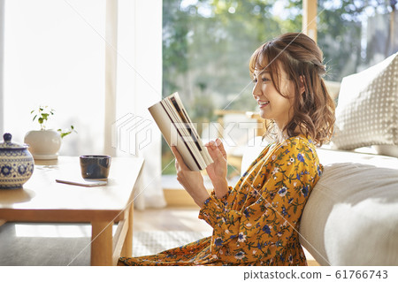 A lady who reads in the living room 61766743