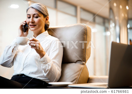 Looking at the cup of coffee while talking stock photo 61766981