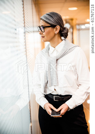 Woman looking outdoors while being in her office stock photo 61767118