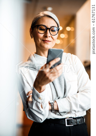 Pretty woman feeling pleased while reading messages stock photo 61767131