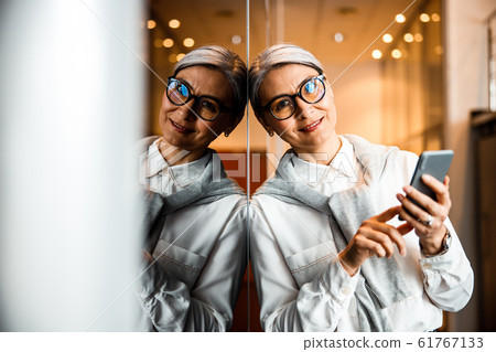 Cheerful office worker with smartphone stock photo 61767133