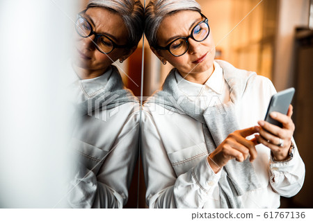 Woman standing and using the Internet in smartphone stock photo 61767136