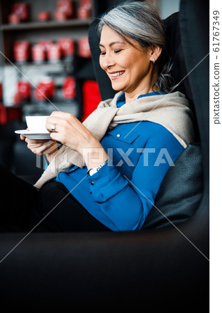 Woman laughing and relaxing with tasty drink stock photo 61767349