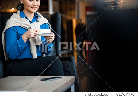 Putting cup on the plate while drinking coffee stock photo Putting cup on the plate while drinking coffee stock photo 61767476
