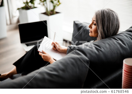 Calm boss sitting alone and looking tired stock photo Calm boss sitting alone and looking tired stock photo 61768546
