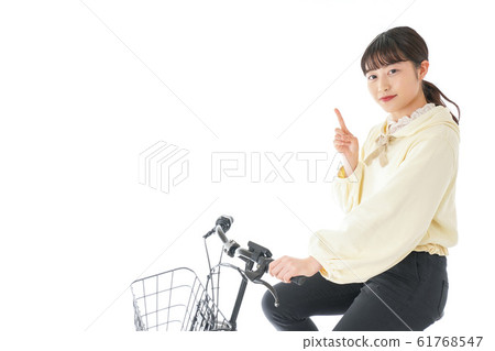 A young woman riding a bicycle 61768547