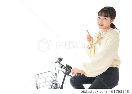 A young woman riding a bicycle 61768548