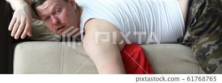 Concerned man lying on coach 61768765