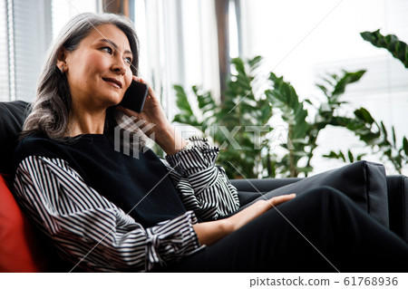 Calm woman listening to business partner on the phone stock photo Calm woman listening to business partner on the phone stock photo 61768936