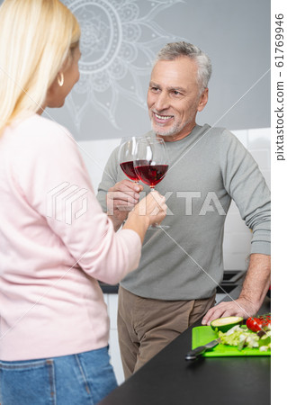 Drinking wine in the kitchen before eating supper stock photo Drinking wine in the kitchen before eating supper stock photo 61769946