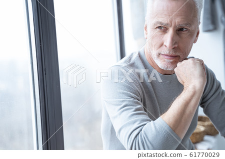 Thoughtful man by the window looking away stock photo 61770029