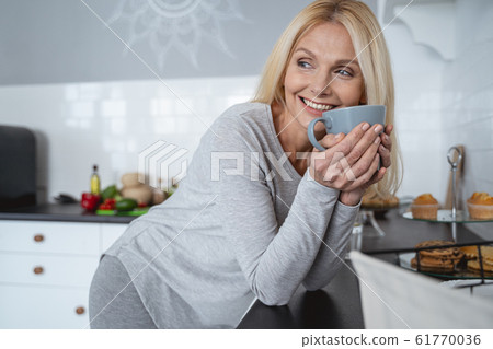 Mirthful person with tasty tea in cup stock photo Mirthful person with tasty tea in cup stock photo 61770036