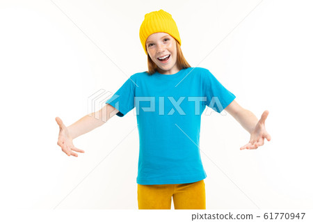 Cool teenager girl with red hair, blue t-shirt and yellow hat isolated on white background Cool teenager girl with red hair, blue t-shirt and yellow hat isolated on white background 61770947
