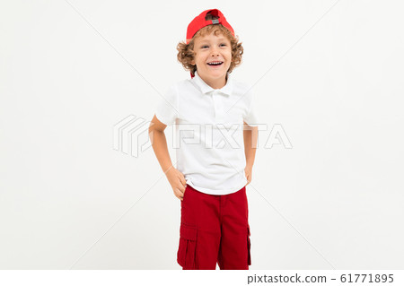 Caucasian boy in white t-shirt, red cap, red shorts smiles isolated on white background Caucasian boy in white t-shirt, red cap, red shorts smiles isolated on white background 61771895