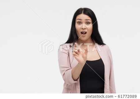 Shocked woman showing small size with fingers Shocked woman showing small size with fingers 61772089