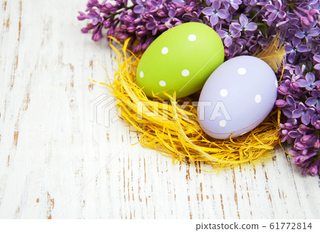 easter eggs and fresh lilac flowers 61772814