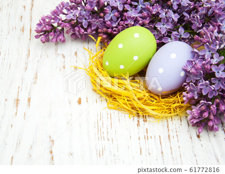 easter eggs and fresh lilac flowers 61772816