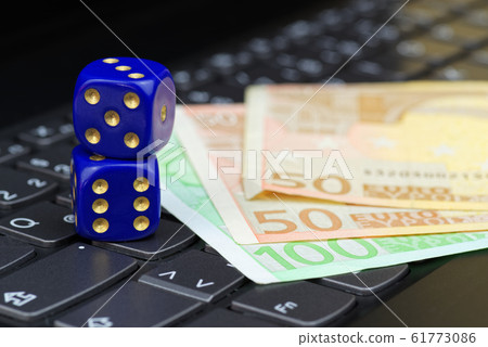 Dices and euro banknotes on computer keyboard Dices and euro banknotes on computer keyboard 61773086