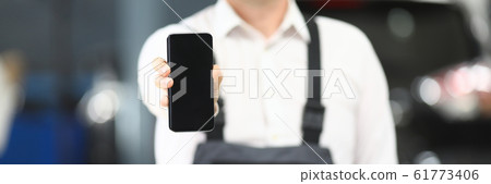 Male in working clothes showing gadget 61773406
